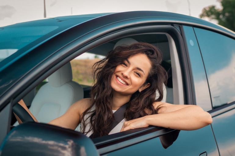 Mujer sonriendo dentro de un carro